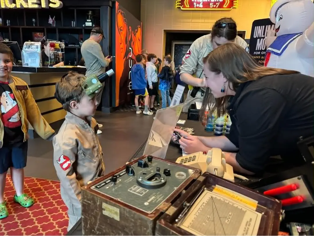 A Ghostbusters Virginia member checking PKE levels with a young fan