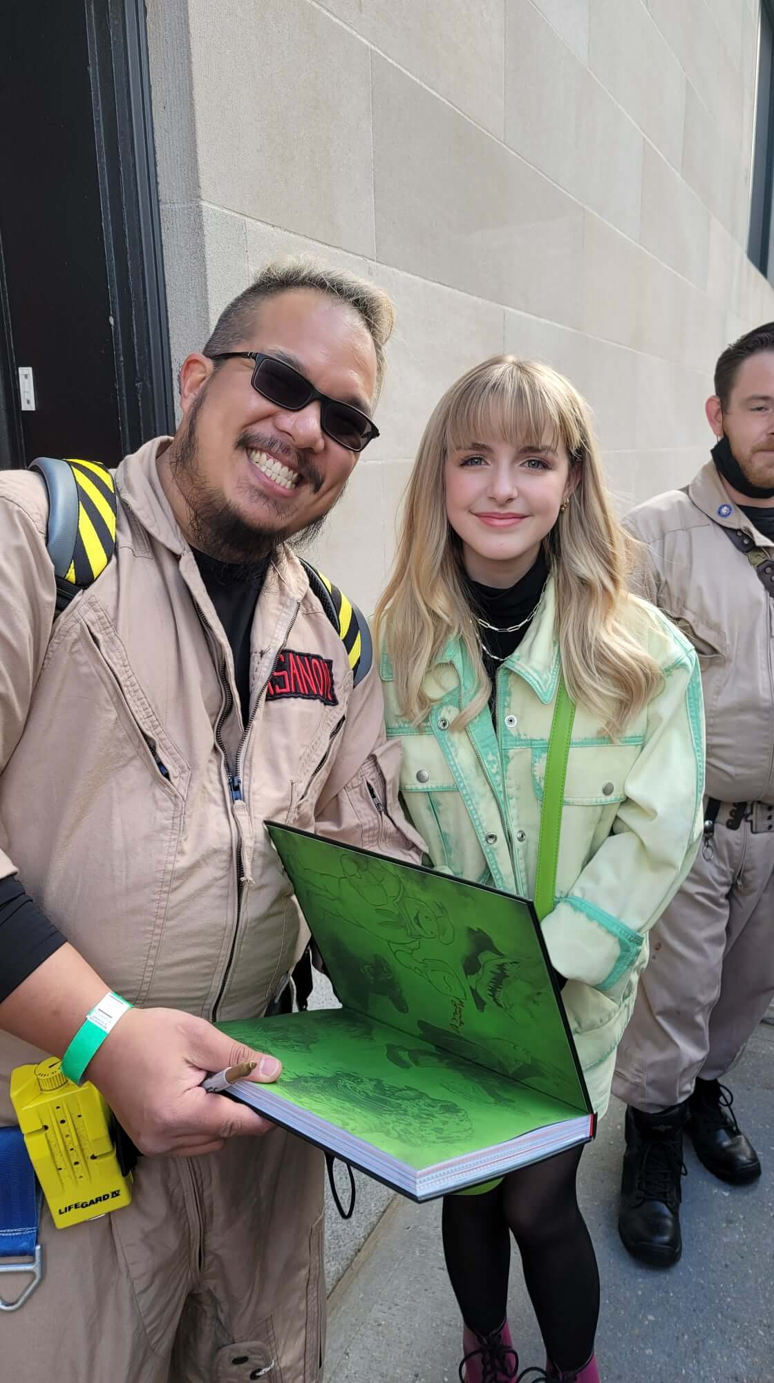 Ghostbusters Virginia members posing with a fan at a comic convention